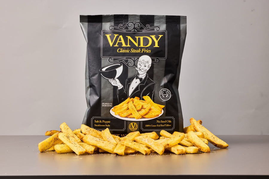 A bag of Vandy Classic Steak Fries, Salt & Pepper, with a pile of golden steak fries dusted with black pepper in front of it